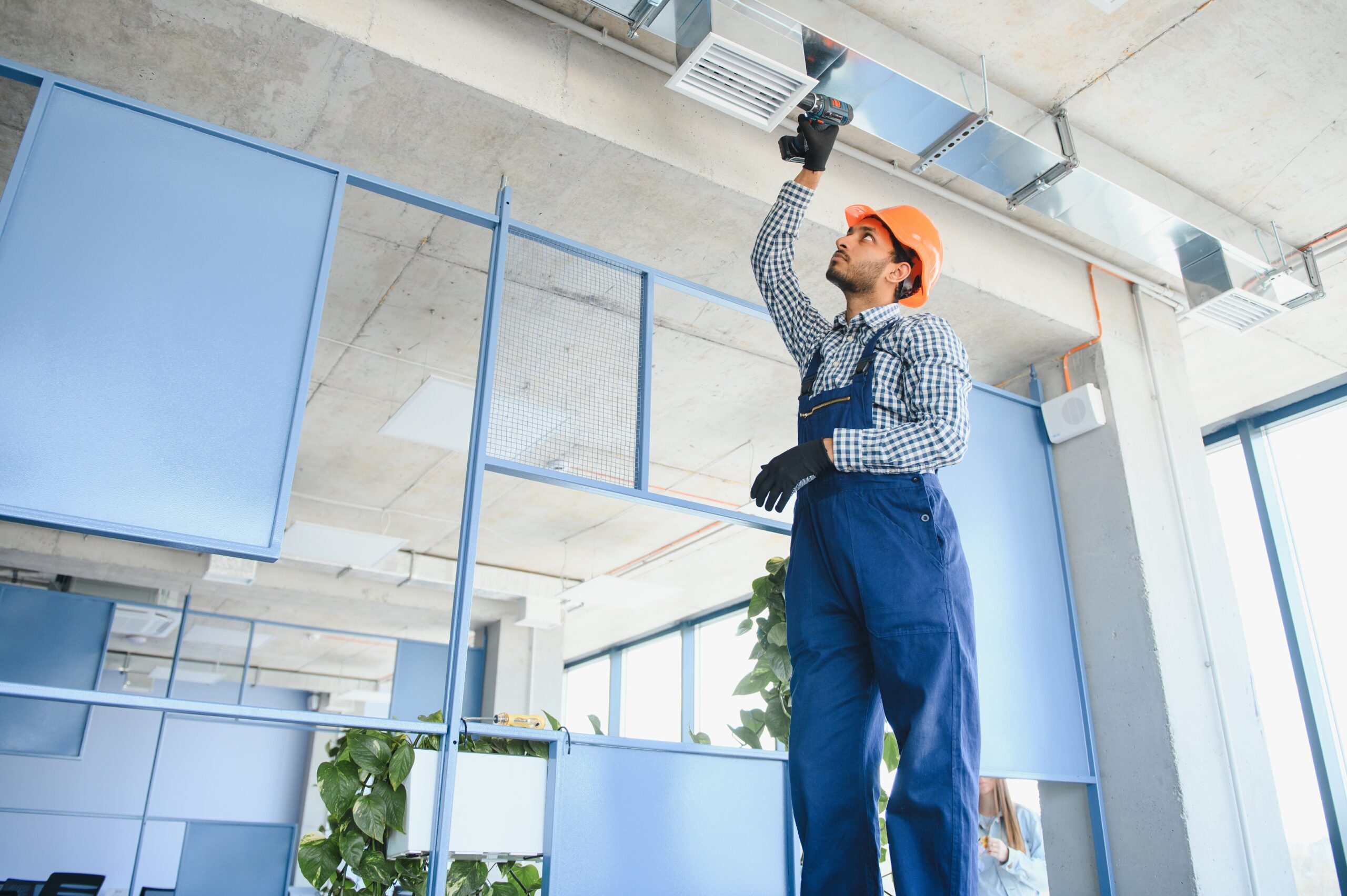 hvac services - indian worker install ducted pipe system for ventilation and air conditioning in house